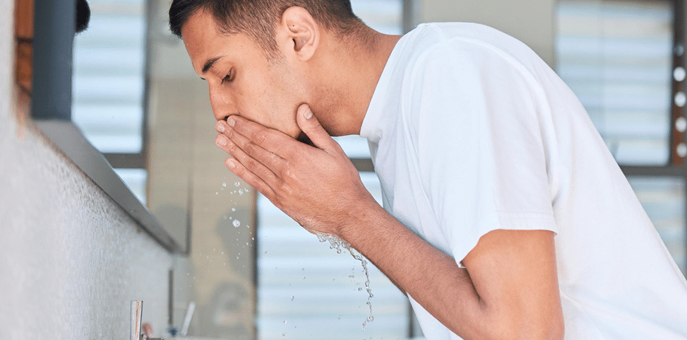 Emergency Dental Care for Tooth Pain and Oral Injuries – Oral Square Dental Melbourne Person rinsing mouth at bathroom sink to relieve dental pain during a dental emergency consultation in Tarneit